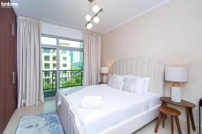 a bedroom with a white bed and a large window at bnbmehomes - Túria Tower A in Dubai