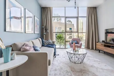 a living room with a couch and a tv at GuestReady - Deluxe Waterfront View in the Marina in Dubai