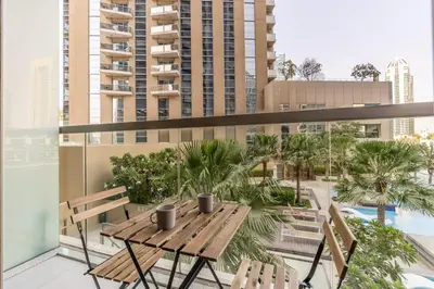 a balcony with a wooden table and two chairs at GuestReady - Deluxe Waterfront View in the Marina in Dubai