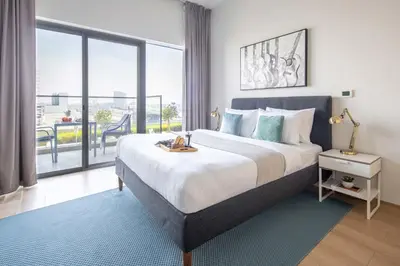 a bedroom with a large bed and a large window at Frank Porter - Azizi Aura in Dubai