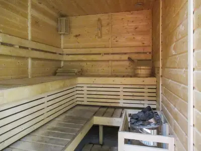 an empty wooden sauna with a bench in it at Frank Porter - Azizi Aura in Dubai