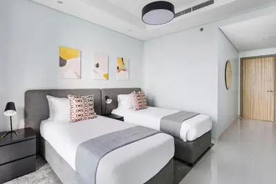 two beds in a room with white walls at ALiving Luxe 2BR with higest Infinity Pool Close to Dubai Mall & Burj Khalifa in Dubai