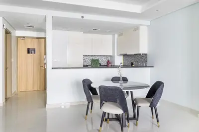 a kitchen and dining room with a table and chairs at ALiving Luxe 2BR with higest Infinity Pool Close to Dubai Mall & Burj Khalifa in Dubai