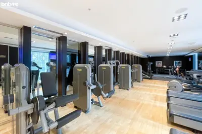 a gym with a row of treadmills at bnbme - Luxury 2BR Near Burj Khalifa Apt Balcony Pool Gym Concierge Near Dubai Mall in Dubai
