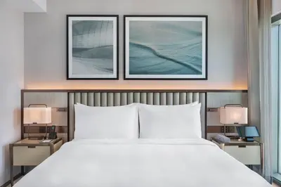a bedroom with a large bed with two pictures on the wall at Address Creek Harbour in Dubai