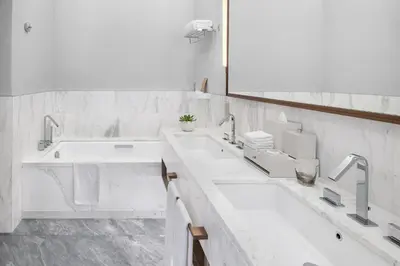 a white bathroom with two sinks and a large mirror at Address Creek Harbour in Dubai