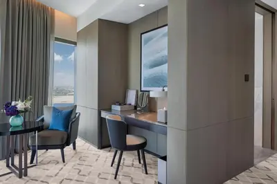 a hotel room with a desk and chairs and a window at Address Creek Harbour in Dubai