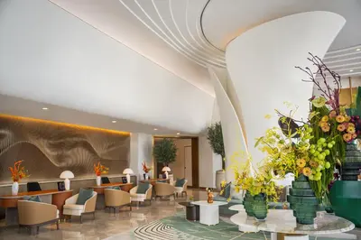 a lobby with couches and tables and flowers at Address Creek Harbour in Dubai