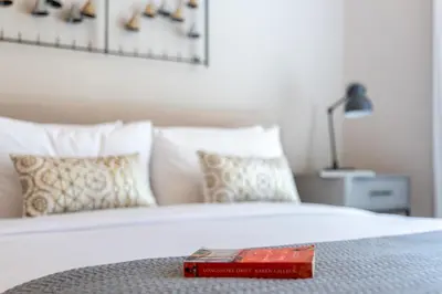 a book sitting on top of a bed with pillows at The Smart Concierge - Marina Scape in Dubai