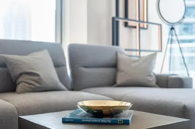 a bowl on a book on a table in front of a couch at The Smart Concierge - Marina Scape in Dubai