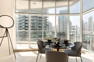 a dining room with a table and chairs and a large window at The Smart Concierge - Marina Scape in Dubai