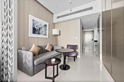 a living room with a couch and a table at ALiving Luxury Studio with Canal Views I DAMAC Maison Prive 2512 in Dubai