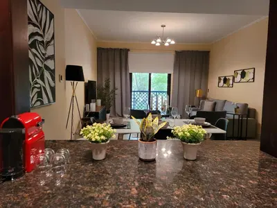 a living room with a table with flowers on it at Luxury 3 Bedroom Apartment - DUBAI MALL 5 min Walk in Dubai