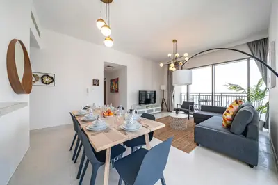 a dining room and living room with a table and chairs at Panoramic Burj Views - Lovely 3BR in Creek Harbour in Dubai