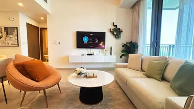 a living room with a couch and a table and a tv at Lovely 1BD canal view apartment in Dubai Marina in Dubai