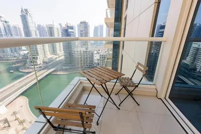two chairs and a table on the balcony of a building at Enticing space With Marina View Near the Beach! in Dubai