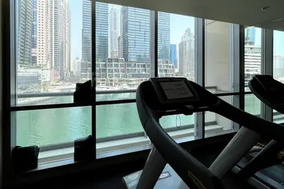 a gym with a view of the city from a window at Dubai Marina, Two bedrooms apartment with full Marina View in Dubai