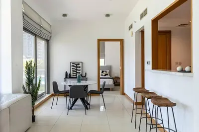 a living room with a table and chairs and a bed at Dubai Marina, Two bedrooms apartment with full Marina View in Dubai