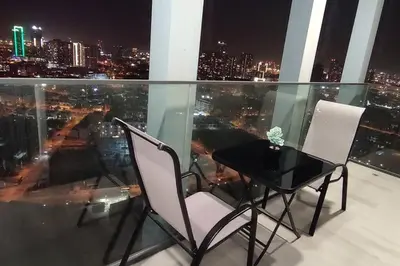 a table and chairs on a balcony with a view of the city at High floor 1BR vacation home with terrace in Dubai