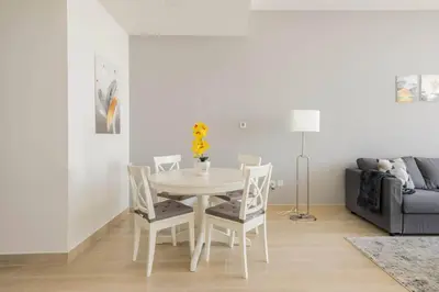 a white table and chairs in a living room with a couch at High floor 1BR vacation home with terrace in Dubai