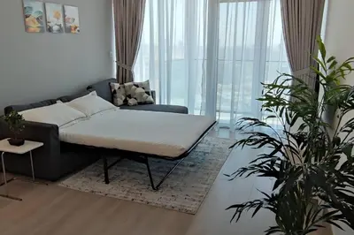 a living room with a bed and a couch at High floor 1BR vacation home with terrace in Dubai