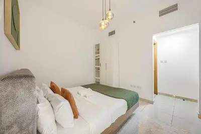 a white bedroom with a bed and a window at Stunning Space with Full Marina View in Dubai