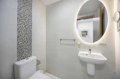 a white bathroom with a sink and a mirror at Stunning Space with Full Marina View in Dubai