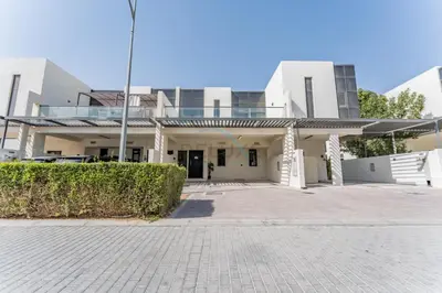 a large white building with a driveway at Flawless 3BR Townhouse with Assistant's Room at DAMAC Hills 2 by Deluxe Holiday Homes in Dubai