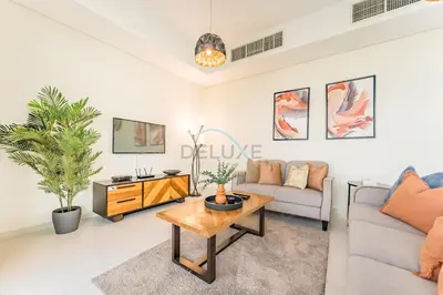 a living room with a couch and a table at Flawless 3BR Townhouse with Assistant's Room at DAMAC Hills 2 by Deluxe Holiday Homes in Dubai