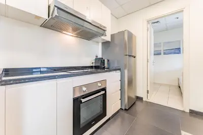 a kitchen with a stove and a refrigerator at Flawless 3BR Townhouse with Assistant's Room at DAMAC Hills 2 by Deluxe Holiday Homes in Dubai