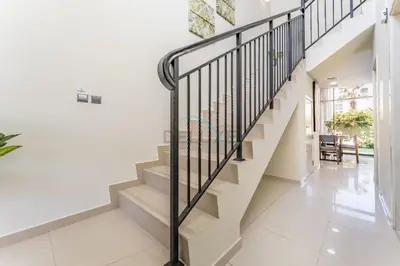 a staircase in a house with white walls and white tile floors at Flawless 3BR Townhouse with Assistant's Room at DAMAC Hills 2 by Deluxe Holiday Homes in Dubai