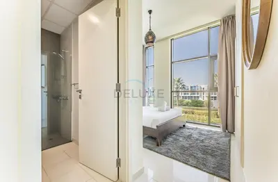 a master bathroom with a shower and a soaking tub at Flawless 3BR Townhouse with Assistant's Room at DAMAC Hills 2 by Deluxe Holiday Homes in Dubai