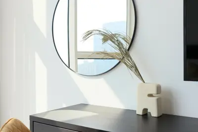 a mirror sitting on top of a dresser in a room at HiGuests - Spacious Apt Near Zabeel Park With Panoramic Views in Dubai