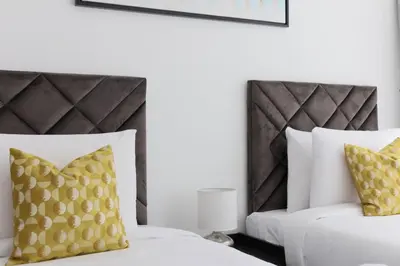 a bedroom with a white bed and yellow pillows at HiGuests - Spacious Apt Near Zabeel Park With Panoramic Views in Dubai