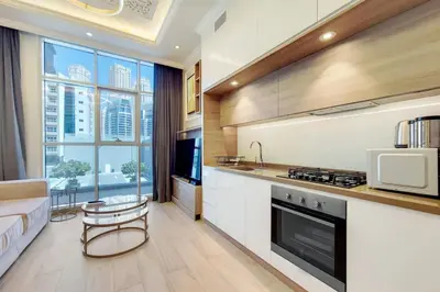a kitchen with a couch and a stove top oven at Studio One - Beautiful One Bedroom in Dubai