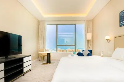 a hotel room with a large bed and a large window at FAM Living - Palm Tower - Palm Jumeirah - Panoramic Studios in Dubai