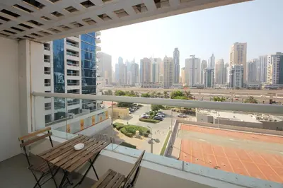 a balcony with a table and chairs and a view of a city at RH- Lovely 1BR apartment in JLT, near metro in Dubai