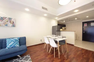 a living room with a table and a blue couch at RH- Lovely 1BR apartment in JLT, near metro in Dubai