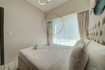 a bedroom with a bed with a mirror and a window at Elegant 1BR with Sofa Bed Close to Metro in Dubai