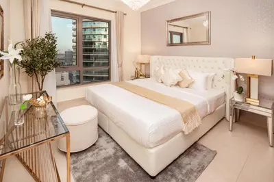 a white bedroom with a large bed and a window at Elite Royal Apartment - Panoramic Full Burj Khalifa, Fountain & Skyline view - Baron in Dubai