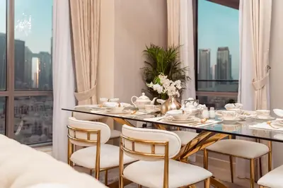 a dining room with a table and chairs and a large window at Elite Royal Apartment - Panoramic Full Burj Khalifa, Fountain & Skyline view - Baron in Dubai