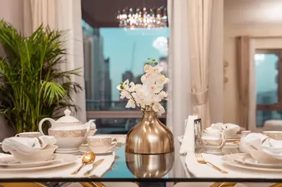 a table with a vase with flowers on it at Elite Royal Apartment - Panoramic Full Burj Khalifa, Fountain & Skyline view - Baron in Dubai