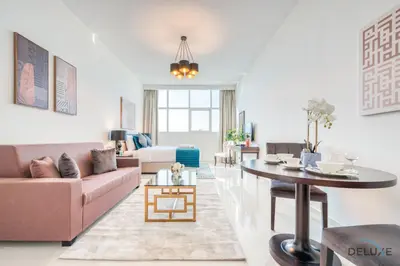 a living room with a couch and a table at Intimate Studio in Damac Ghalia Jumeirah Village Circle by Deluxe Holiday Homes in Dubai