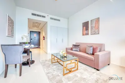a living room with a couch and a table at Intimate Studio in Damac Ghalia Jumeirah Village Circle by Deluxe Holiday Homes in Dubai