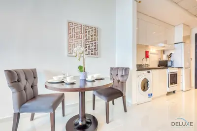 a dining room with a table and two chairs at Intimate Studio in Damac Ghalia Jumeirah Village Circle by Deluxe Holiday Homes in Dubai