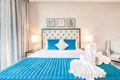 a blue and white bedroom with a bed with a blue and white bedspread at Peaceful Studio at Celestia A Dubai South by Deluxe Holiday Homes in Dubai