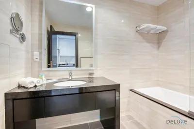 a bathroom with a sink and a tub and a mirror at Peaceful Studio at Celestia A Dubai South by Deluxe Holiday Homes in Dubai