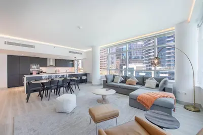 a living room with a couch and a table and a kitchen at Astonishing 3BDR in the heart of Dubai Marina in Dubai