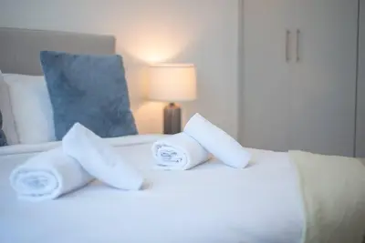 a white bed with three rolled towels on it at Astonishing 3BDR in the heart of Dubai Marina in Dubai