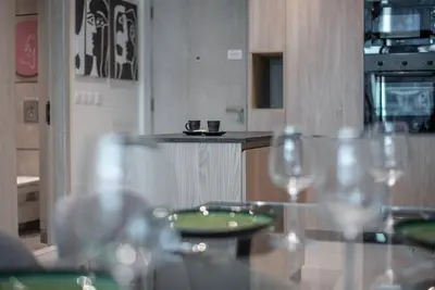 a table with glasses and a green plate on it at Modern flat with KING SIZE bed and HIGH SPEED Wifi in Dubai